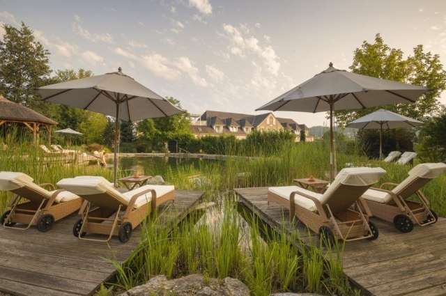 Lädt zum Verweilen ein: Liegen am Naturteich – ©Garten Hotel Ochensberger