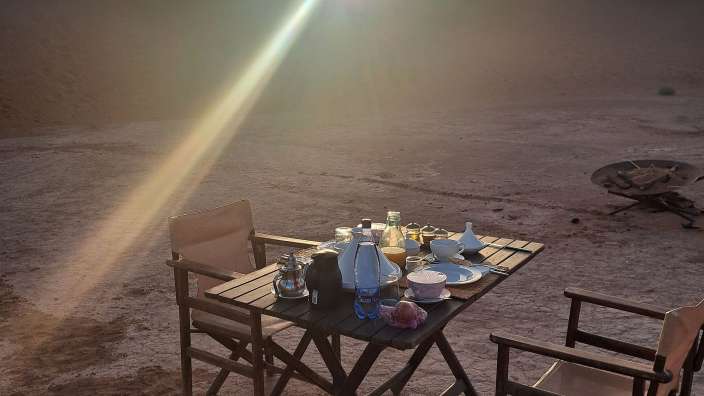 Sonnenaufgang im Camp mit Frühstückstisch